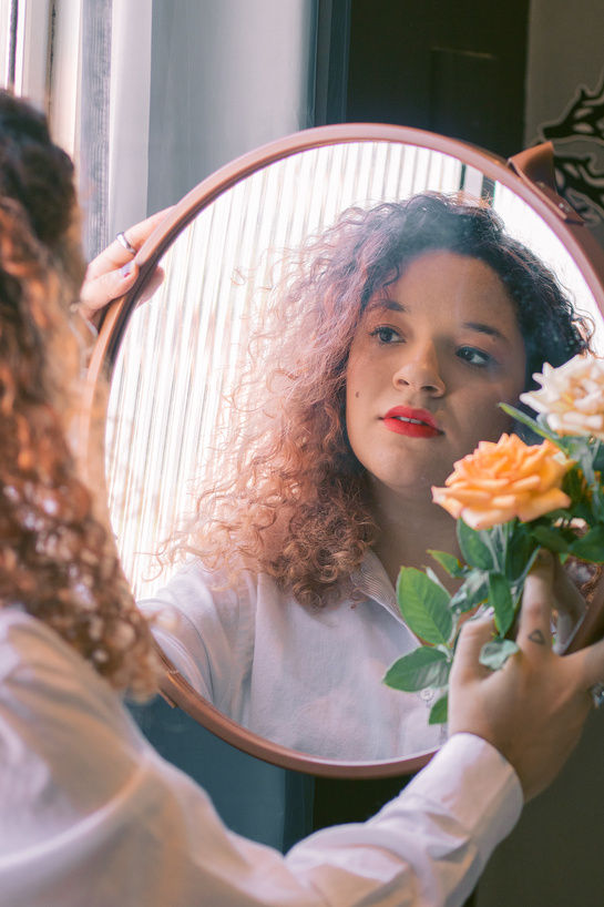 Woman looking in mirror reflection in room